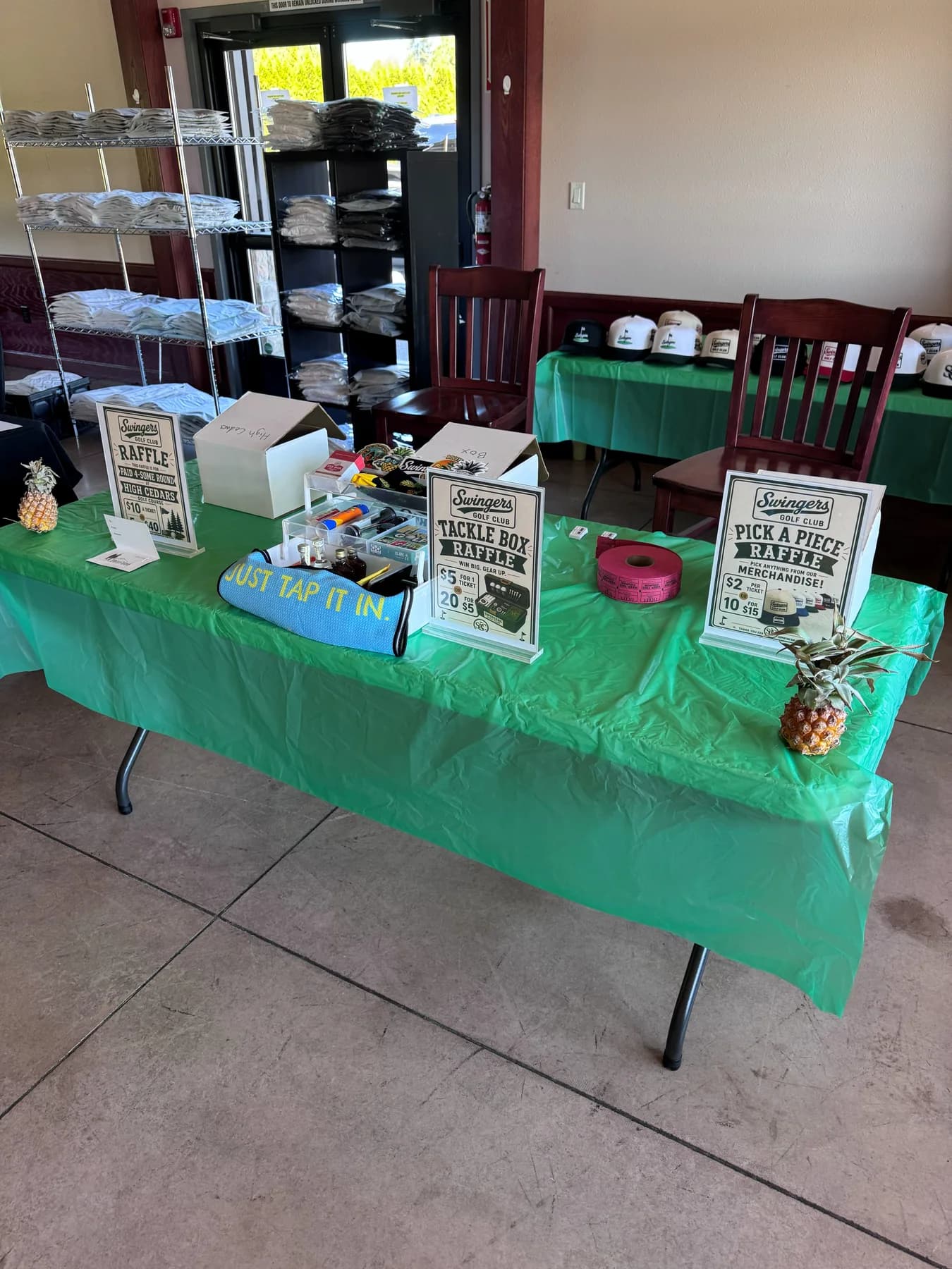 Merch table, raffle box, first-wave gear.